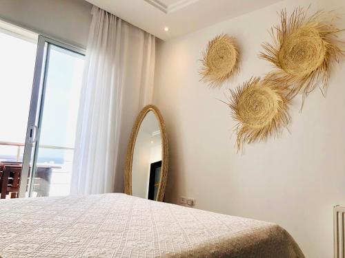 - une chambre avec un lit et un grand miroir dans l'établissement Byblos Sousse, à Sousse
