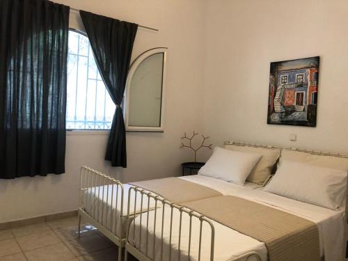 1 dormitorio con cama y ventana en Olea Home en Agia Pelagia Chlomou