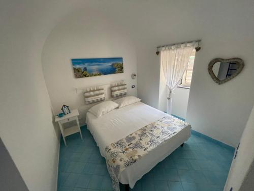 Dormitorio pequeño con cama y espejo en La Casa di Paola, en Nerano
