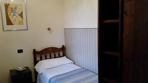 a small bedroom with a bed with white sheets at Hotel Croce Di Malta in Rome