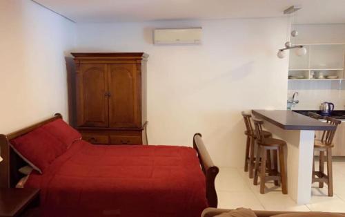 een woonkamer met een rode bank en een tafel bij Flat Deluxe Gramado in Gramado