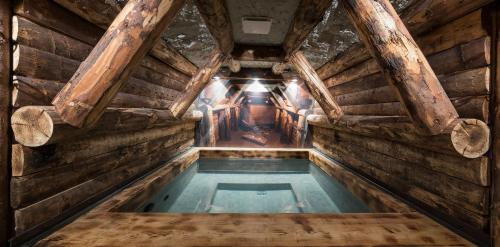 a swimming pool in a wooden house with a ceiling at La mine de Buck in Le Biot