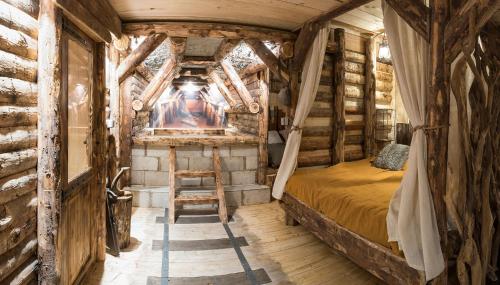 sypialnia z łóżkiem w pokoju z drewnianymi ścianami w obiekcie La mine de Buck w mieście Le Biot