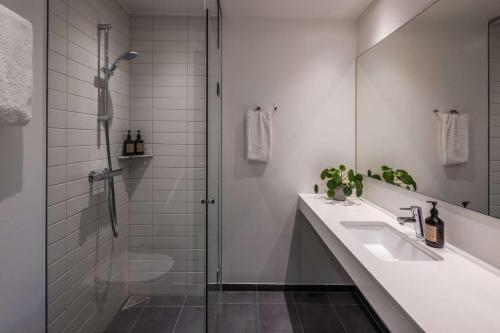 La salle de bains est pourvue d'un lavabo et d'une douche. dans l'établissement Peak 12 Hotel, à Viborg