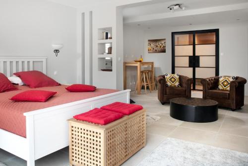 a bedroom with a large bed with red pillows at La perle rouge A Panazol in Panazol