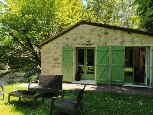 a green shed with a table and chairs in the grass at L'Orée de Giverny in Limetz