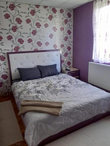 ein Schlafzimmer mit einem großen Bett mit Blumentapete in der Unterkunft Guest house Obzor in Obsor