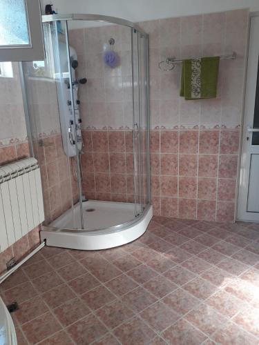 a shower with a glass door in a bathroom at Guest house Obzor in Obzor