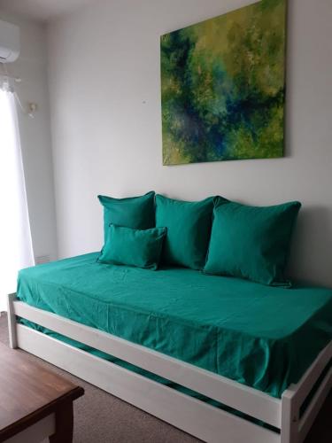 a bed with green pillows in a room at Parque Patricios 2 ambientes in Buenos Aires