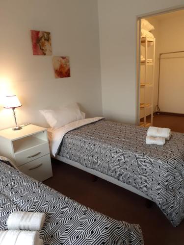 ブエノスアイレスにあるParque Patricios 2 ambientesのベッドルーム1室(ベッド2台、ランプ、鏡付)