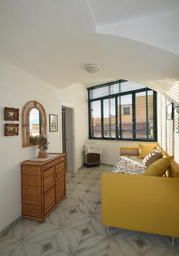 a living room with a yellow couch and a table at Casa del Capitano in Vico Equense