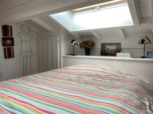 - une chambre avec un lit et une couverture rayée colorée dans l'établissement Chambre des Chenets, à Samoëns