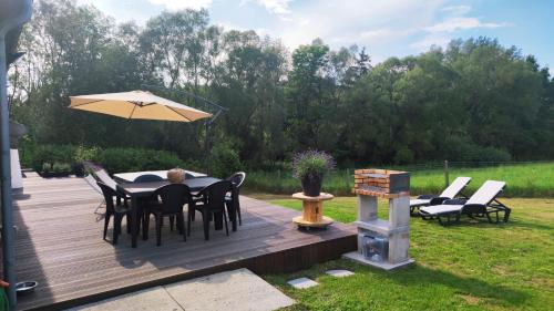 a deck with a table and chairs and an umbrella at Villa ADurbuy avec Jacuzzi in Durbuy