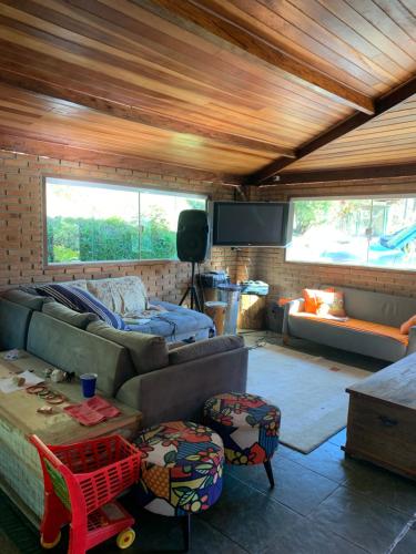 a living room with a couch and a tv at Chales em Salesopolis - Recanto da Barra in Salesópolis