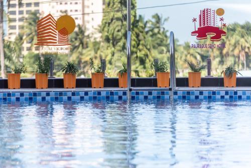 una piscina con macetas junto al agua en Pauraque Soho Hotel en Dar es Salaam