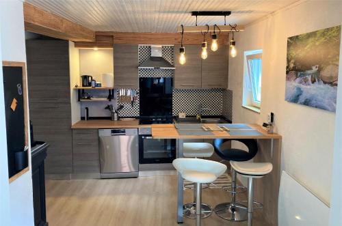 una cocina con encimera y taburetes. en Grand T2 4 voyageurs tout confort en Cauterets