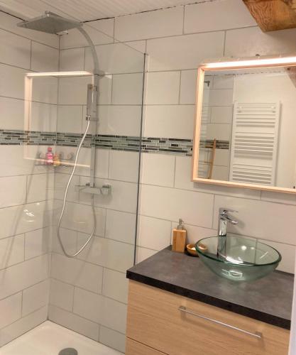 La salle de bains est pourvue d'une douche, d'un lavabo et d'un bol en verre. dans l'établissement Grand T2 4 voyageurs tout confort, à Cauterets