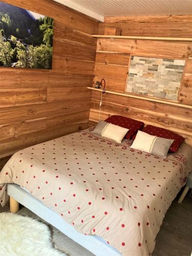 - une chambre avec un lit et un mur en bois dans l'établissement Grand T2 4 voyageurs tout confort, à Cauterets