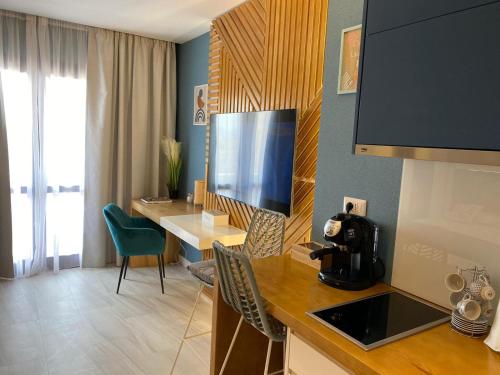 a room with a kitchen with a table and a television at GoConcept Studio Sardegna in Olbia