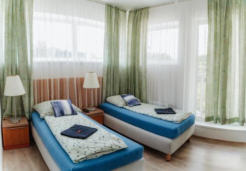 Duas camas num pequeno quarto com janelas em Dudok House em Žilina