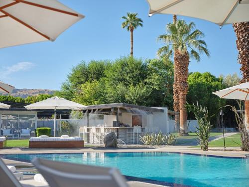 a swimming pool with chairs and umbrellas at L'Horizon Resort & Spa, Hermann Bungalows in Palm Springs