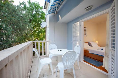 a balcony with a table and chairs and a bed at Villa Ban in Podgora