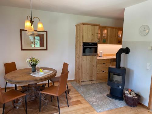 a kitchen and dining room with a table and a wood stove at Klösterle Haus Egon in Arriach