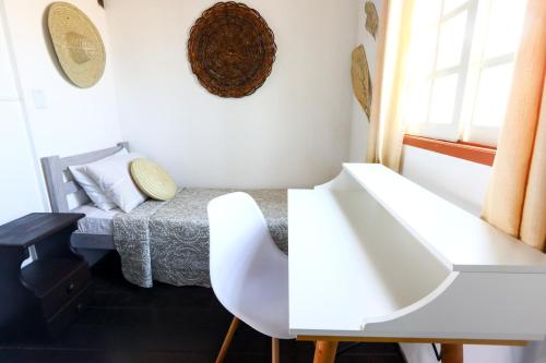 a white room with a bed and a white chair at Hospedaria Tayrona in Lençóis