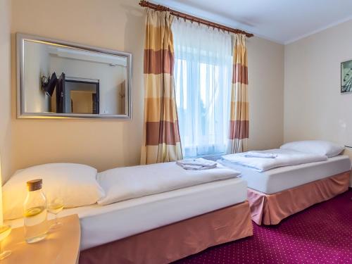 een hotelkamer met 2 bedden en een spiegel bij VacationClub – 300 Mill Pokój 3 in Szklarska Poręba