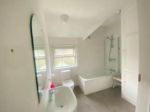 a bathroom with a sink and a tub and a mirror at Ravelstone in Church Stretton