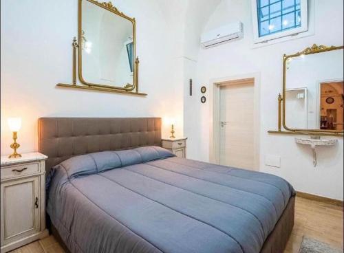 1 dormitorio con 1 cama grande y espejo en Dimora luxury Santa Lucia Apartaments, en Galatone