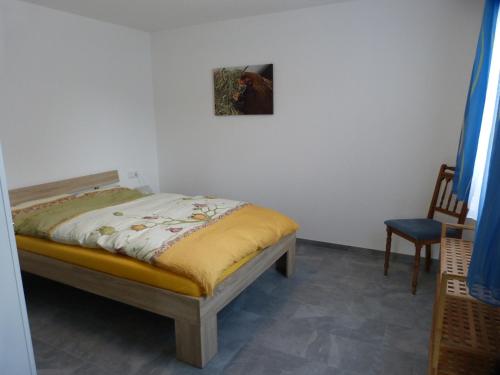 uma cama num quarto com uma pintura na parede em Ferienwohnung am Hirtenpfad em Lenzkirch