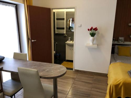 a dining room with a table and a bedroom at Milla Apartman in Szentendre