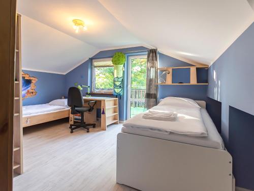 a bedroom with two beds and a desk and a chair at VacationClub - 300 Mill Pokój 6 in Szklarska Poręba