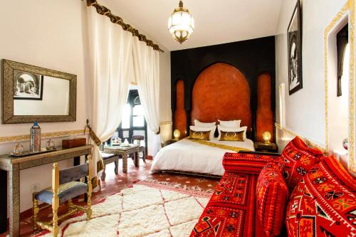 een slaapkamer met een groot bed met een rood hoofdeinde bij Riad en exclusivité Maison d hôtes Chamade & Spa in Marrakesh