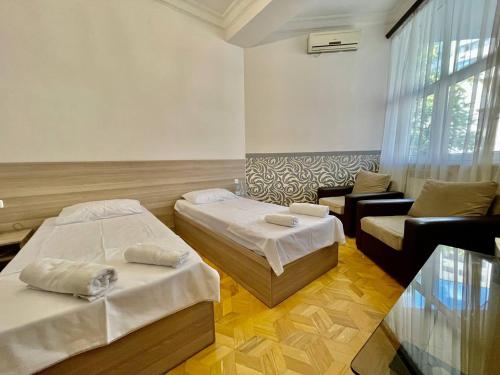 a hotel room with two beds and a couch at Olive hotel in Yerevan
