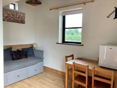 a bedroom with a bed and a table and a window at Brecks Cottage in Newark upon Trent