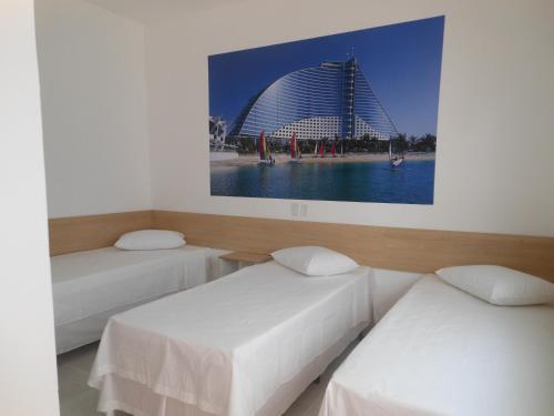 two beds in a room with a building in the background at Pousada Dubai in Taubaté