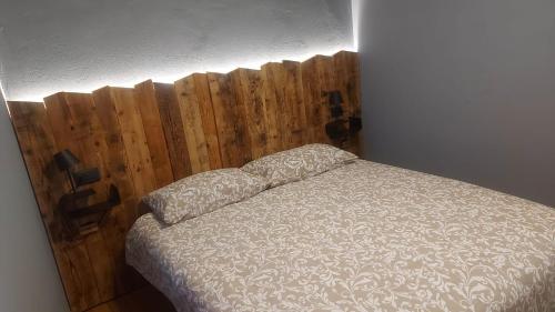 1 dormitorio con 1 cama con cabecero de madera en Appartamenti il Bersaio Alloggio 1 en Sambuco