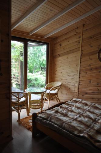 a bedroom with a bed and a table and chairs at Villa Beata in Nowe Warpno