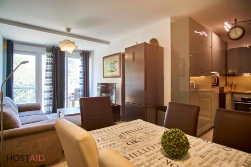 een keuken en een woonkamer met een tafel en stoelen bij SunGarden Apartments - hostAID in Siófok