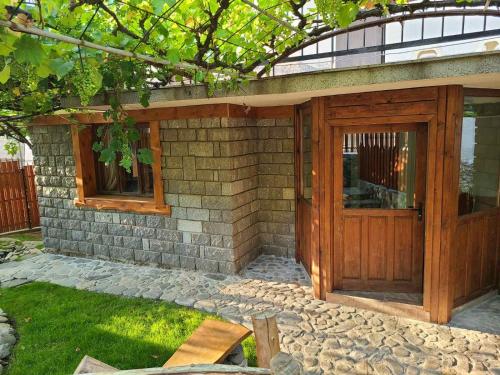 a brick building with a wooden door in a yard at Вила 111 in Sapareva Banya