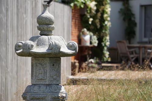 a stone fountain in a yard with a woman in the background at Bed 'n Blues **** in Halen