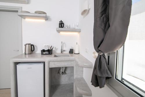 baño pequeño con lavabo y ventana en Sensia Luxury Apartment with Hot tub, en Oia
