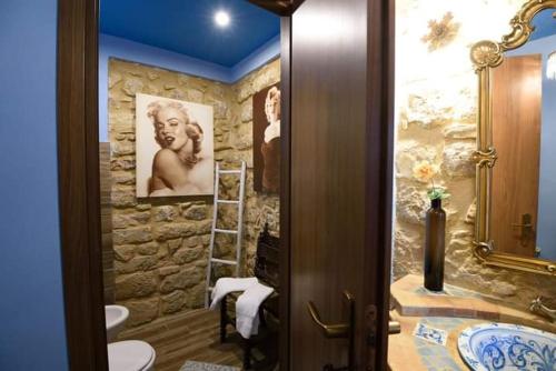 a bathroom with a stone wall with a sink at Kimera in Piazza Armerina