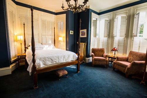 1 Schlafzimmer mit einem Bett und 2 Stühlen in der Unterkunft Brasswood Inn in Provincetown