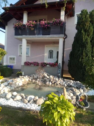 a house with a small pond in front of it at Apartman Karmen Gospić in Gospić