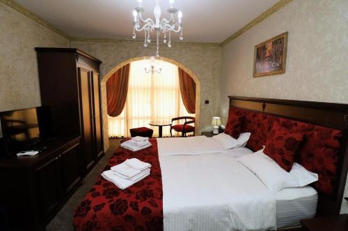 a bedroom with a large bed with a red blanket at aSa Boutique Hotel in Haskovo