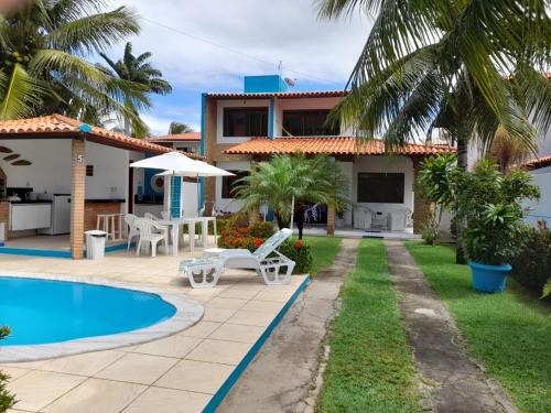a villa with a swimming pool and a house at Casa de praia aconchegante em Sonho Verde in Paripueira