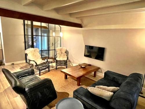 een woonkamer met een bank en een tafel en stoelen bij Vakantiehuisje op de Veluwe! in Beekbergen